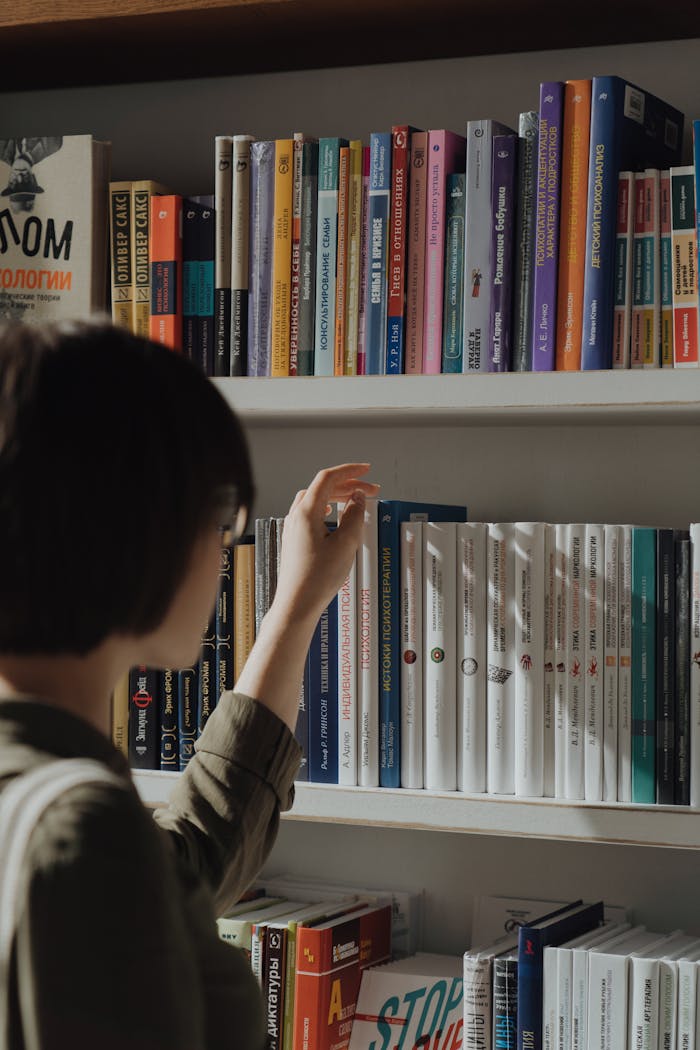 services-04 A person browsing a diverse bookshelf, highlighting learning and leisure in a library.