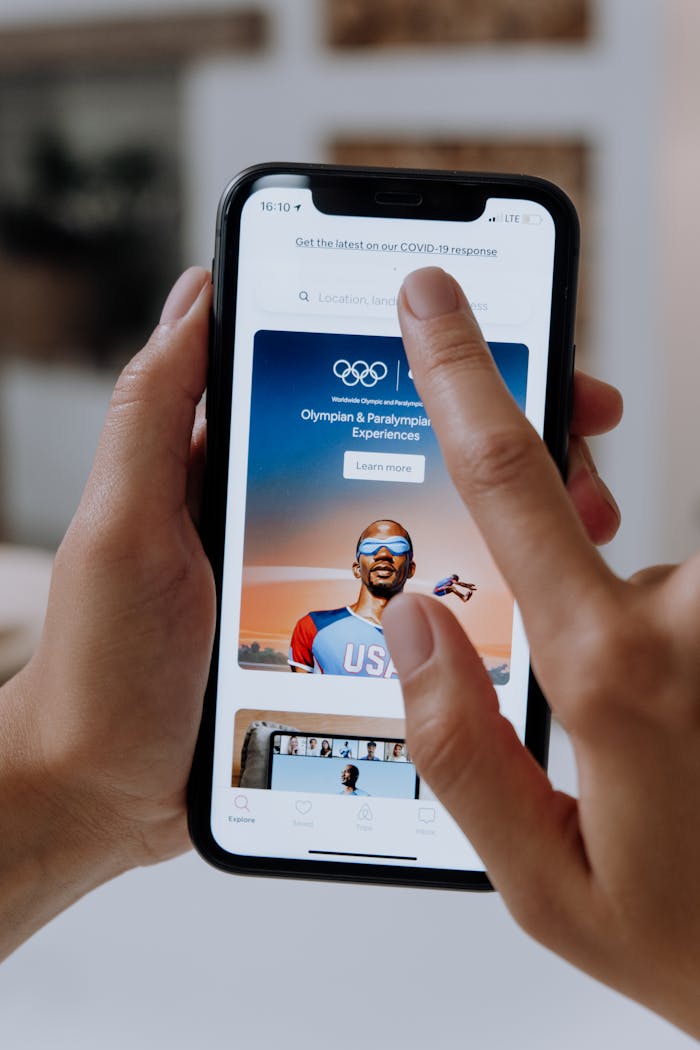 Close-up of hands interacting with a smartphone displaying an e-commerce platform.